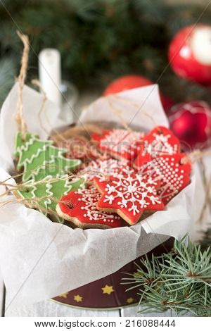Gingerbread In A Tin Box In The Background With Christmas Toys, A Candle And Fir Branches.