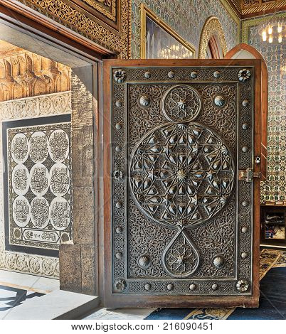 Cairo, Egypt - October 21, 2017: Opened wooden aged door with ornate bronzed floral patterns at the mosque of The Manial Palace of Prince Mohammed Ali Tewfik Cairo Egypt