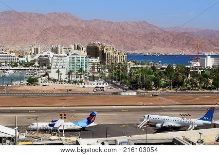 Eilat, Israel - MAY 24: plane of israeli airline Israir, landed at the airport of Eilat on the background of luxurious hotels, Israel, on May 24, 2017 in  Eilat, Israel