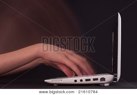Ręce wpisując w ruchu na klawiaturze laptopa