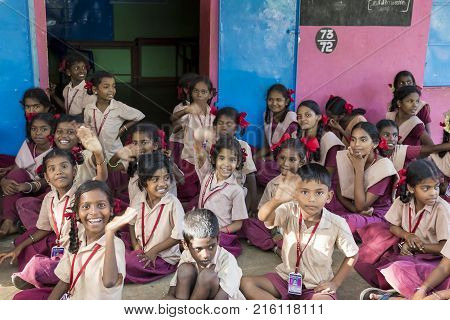 PONDICHERY PUDUCHERY INDIA - SEPTEMBER 04 2017. Outdoor meeting of the children of the school with uniforms sitting on the floor waiting for sport equipments as a gift from an association.
