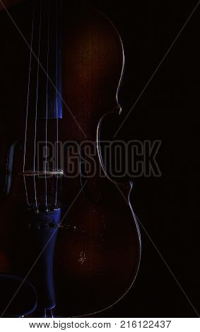 Accentuated shapes of violin with light illuminated in dark.
