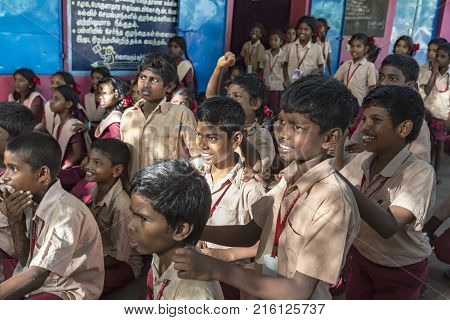 PONDICHERY PUDUCHERY INDIA - SEPTEMBER 04 2017. Outdoor meeting of the children of the school with uniforms sitting on the floor waiting for sport equipments as a gift from an association.