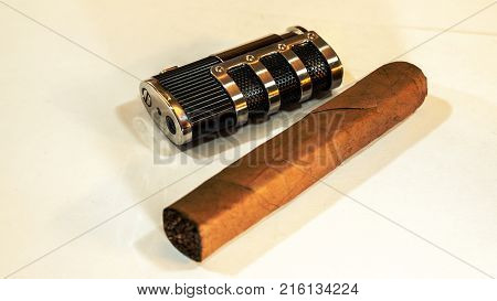 Metal Lighter and cigar cuter on white backdrop