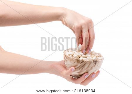 White beans in a pial plate of female hands on a white background isolation