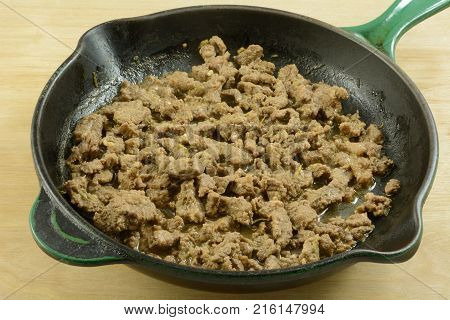 Stir fry strips of beef in cast iron frying pan skillet