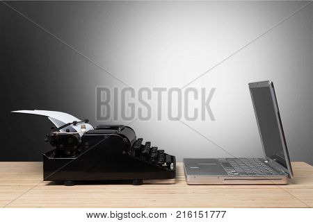 Old laptop top typewriter old and new now and then table