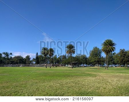 Kapiolani Park and tennis courts with plane in the air on Oahu Hawaii.