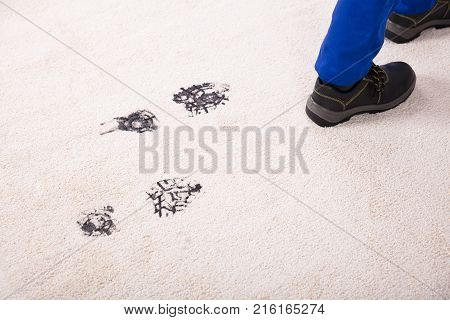 Elevated View Of Person Walking With Muddy Footprint On Carpet