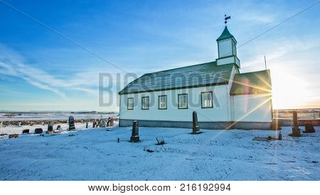 Typical green colored wooden church, Iceland in winter. Sunrise light