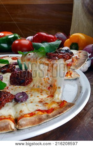 Pizza with mozzarella, rucula and dried tomato