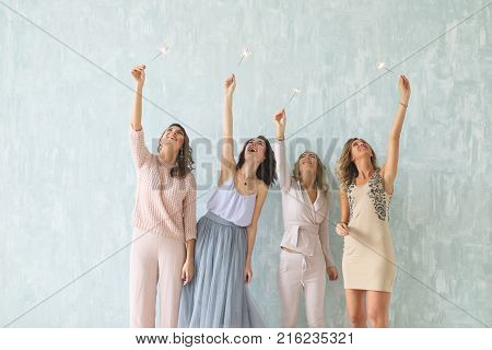 new year party, christmas, party, holidays, winter holidays and people concept - happy young women with sparklers