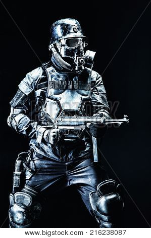 Futuristic nazi soldier gas mask and steel helmet with schmeisser handgun black background studio shot