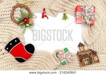 Christmas and new year ornament and gift box on winter knitted scarf on white. Isolated on white