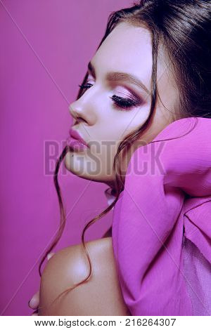 Beautiful Fashionable Girl Haired With Long Curly Hair Posing With A Pink Bow. The Girl In The Studi