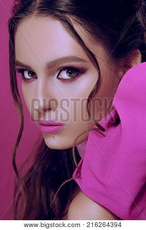 Beautiful Fashionable Girl Haired With Long Curly Hair Posing With A Pink Bow. The Girl In The Studi
