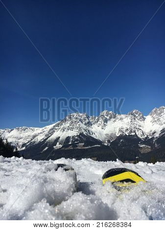 Ski tails in the snow in front of Wilder Kaiser Mountains