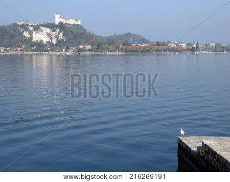 View of the mountains Maggiore lake and a castle from the coast of Arona