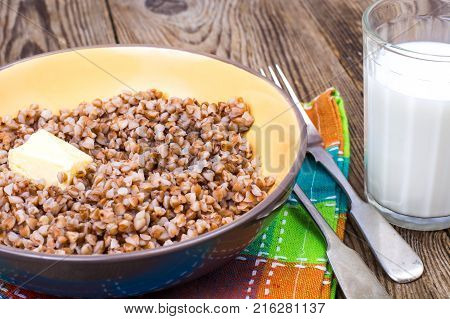 Delicious buckwheat porridge with butter and milk. Studio Photo