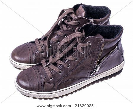 Brown women's boots with laces on white soles. Studio photo