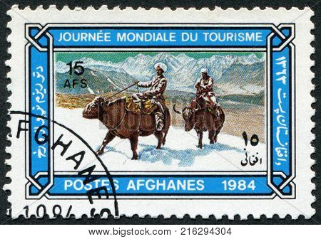 AFGHANISTAN - CIRCA 1984: A stamp printed in the Afghanistan devoted to World Tourism Day. Depicts Buffalo riders in snow, circa 1984