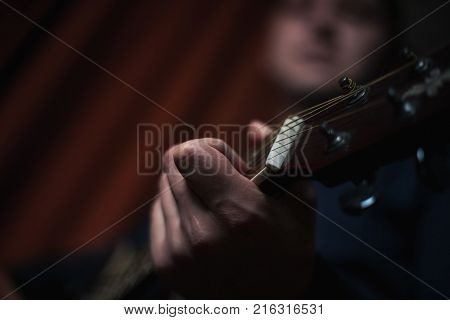 The Guitarist Guy plays the guitar in a bar in a beautiful setting on a high bar stool