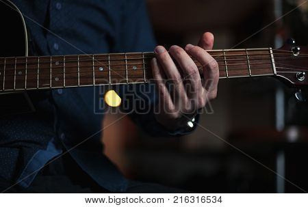 The Guitarist Guy plays the guitar in a bar in a beautiful setting on a high bar stool