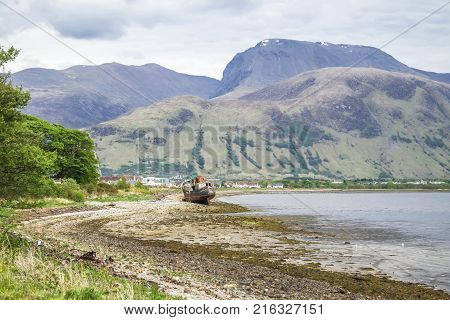 View across Loch Linnhe beyond an abandoned boat towards Ben Nevis, the highest mountain in Great Britain