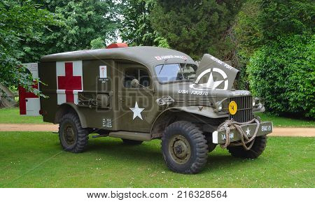 SILSOE, BEDFORDSHIRE, ENGLAND - MAY 28, 2017:  Second World War  Ambulance parked in front of trees.