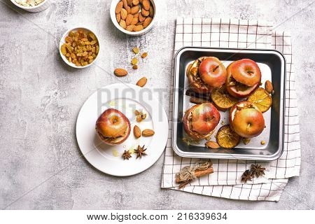 Stuffed apples with granola cinnamon nuts and honey on stone background. Healthy ftuit dessert. Top view flat lay