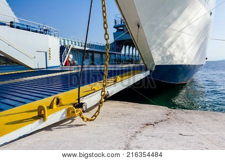 Anchored large ferryboat has open front entrance at the local port.