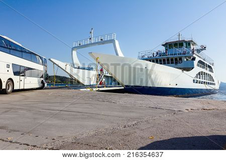 Large ferryboat has opened his front gate for boarding busses and other vehicles at the local port.
