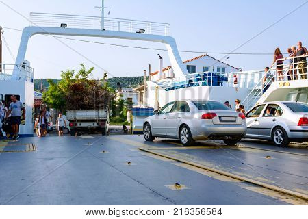 Pefki Island Evia Greece - 11 July 2017: Anchored large ferryboat has opened his front entrance for unloading people tourists and vehicles at the local harbor