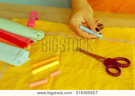 closeup of woman hands sewing yellow cloth outdoors. Woman's Hand Sewing Quilt