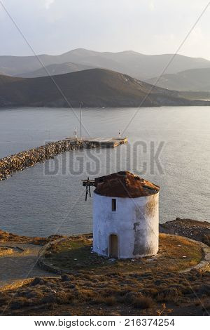 Windmill on a slope of a hill over Psara village overlooking its harbour.