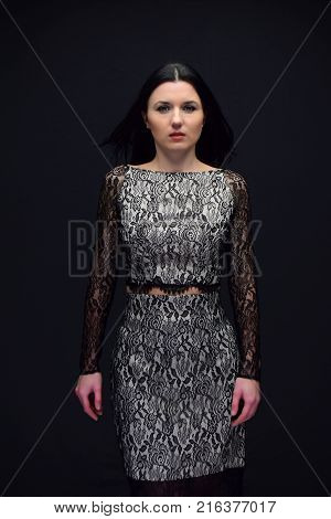 beautiful young woman. The woman is a brunette with long hair and green eyes.the woman is located against a dark background