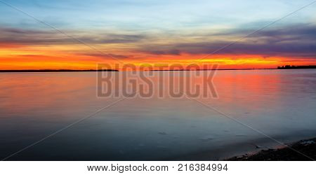 Nightfall overlooking Lac St Louis Lachine Quebec from the walking path with the sun behind the horizon.