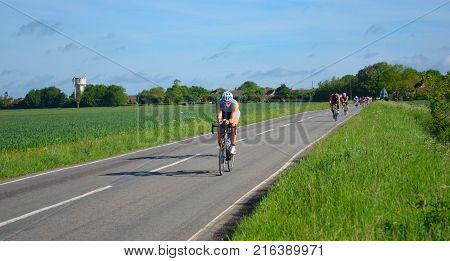 GRAFHAM, CAMBRIDGESHIRE, ENGLAND - MAY 21, 2017:  Triathletes on road cycling stage of triathlon.