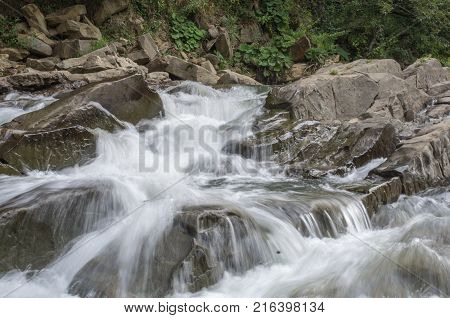 Peaceful forest river flow down among stones in summer Bieszczady