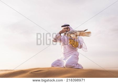 Arabian man walking in the desert at sunrise