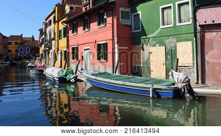 BURANO, VENICE, ITALY -  SEPTEMBER 21, 2017:  Colorful houses boats and canal of Burano Island in the Venetain Lagoon.