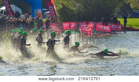 GRAFHAM, CAMBRIDGESHIRE, ENGLAND - MAY 21, 2017:  Triathlon swimmers entering open water swim stage.