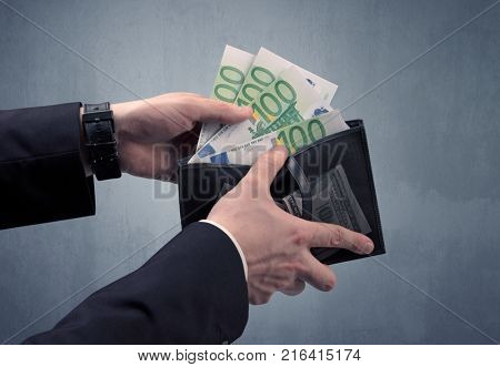 Businessman's hand in suit takes out eruo from his wallet
