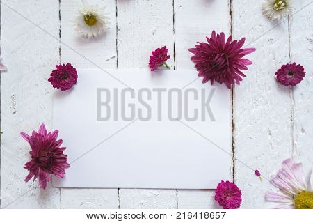 Multicolored flowers on a white wooden mocap background