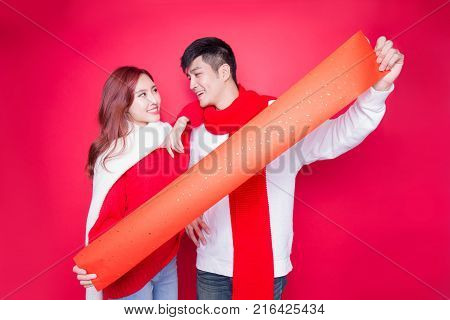 couple show couplets with chinese new year on red background