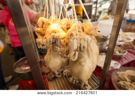 Boiled Chicken is hung up in glass showcases. Chicken and rice steamed served with chicken soup, Thai Food.