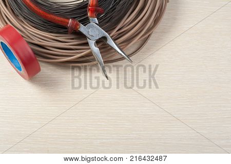 Electrical tools and cable on wooden table.Copy space for text. Energy concept.