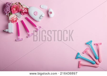 Female epilator and four disposable pink razors with roses, lie on a pink background in the upper left corner, in the lower right corner are five disposable razors, free space for text.