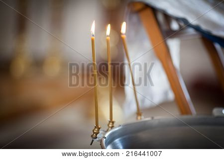 three church candles on a black background