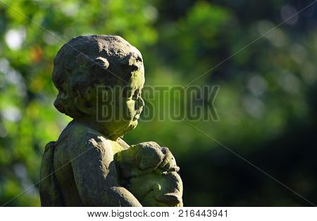 Silsoe, Bedfordshire, England - October 27, 2017: Detail of statue of small boy with puppy,